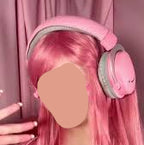 Person with pink hair and headphones against a pink curtain background